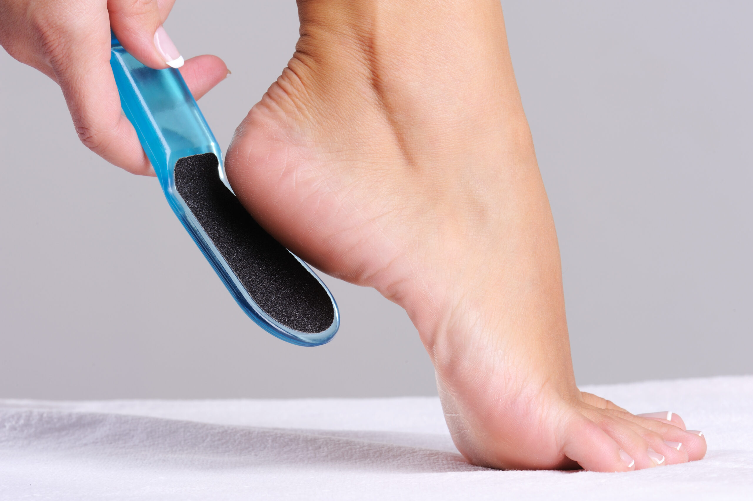 woman scrubbing heel in beauty salon use the tool for pedicure